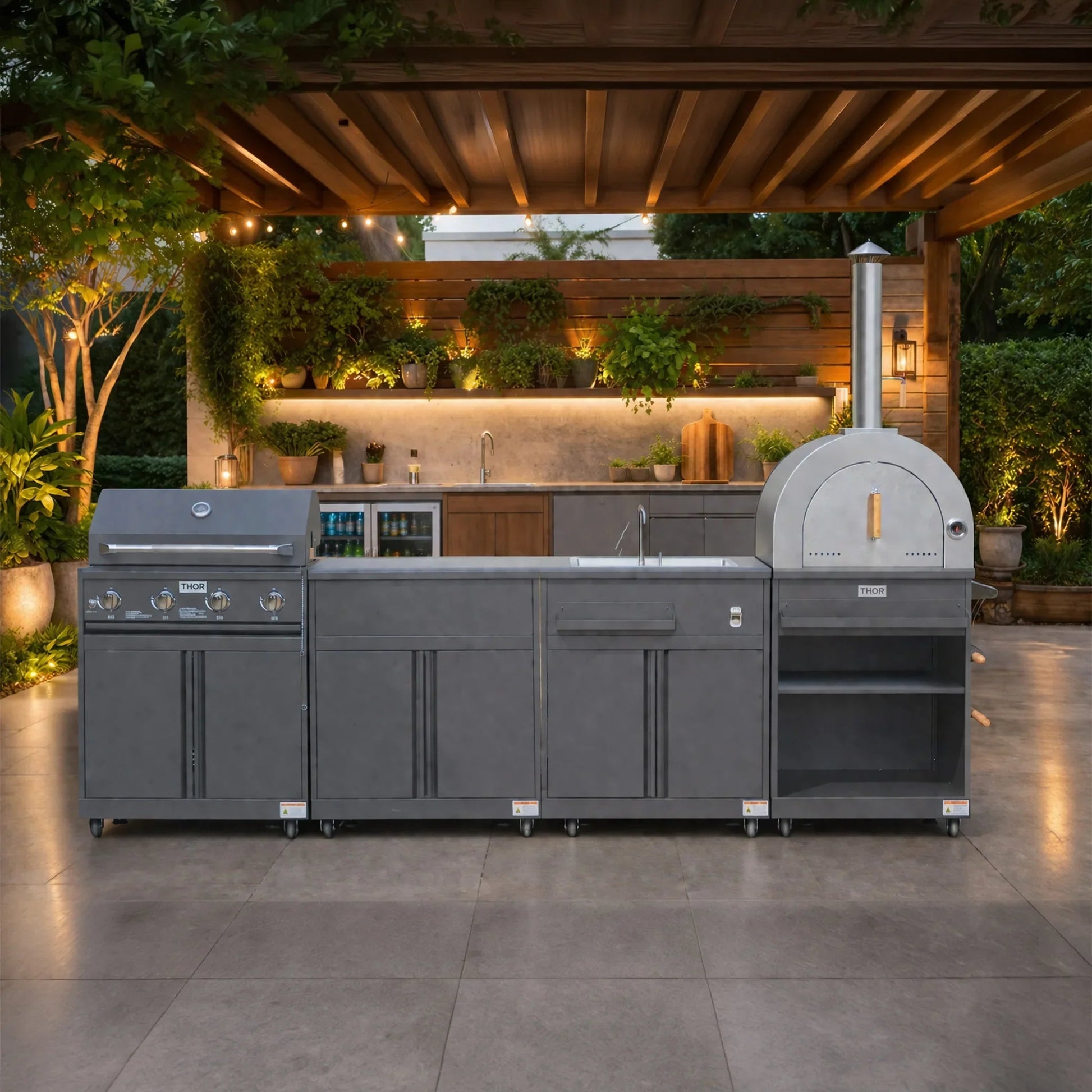 Modern outdoor kitchen with stainless steel grill, pizza oven, sink and garden lighting